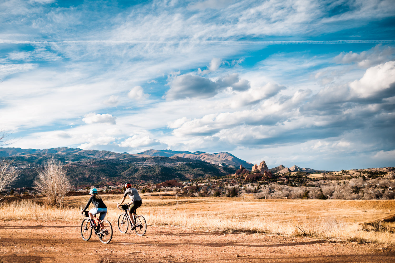 Two bikepackers riding through a scenic overlook with handlebar bags on their bikes