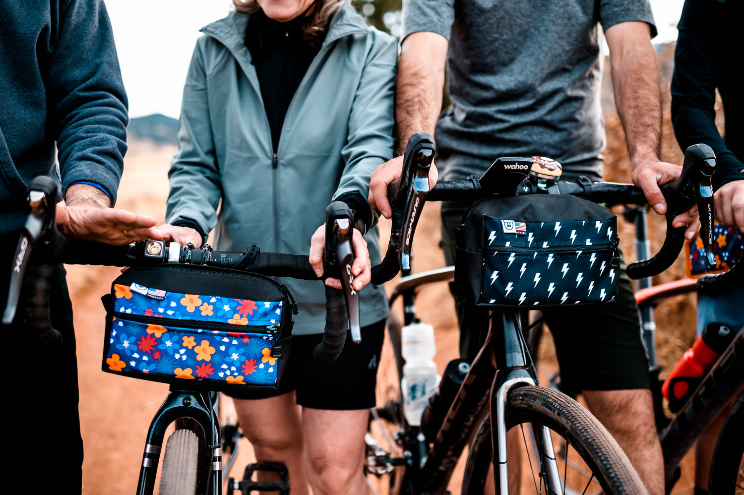 A close up shot of a floral handlebar bag and a black and white lightning bolts handlebar bag