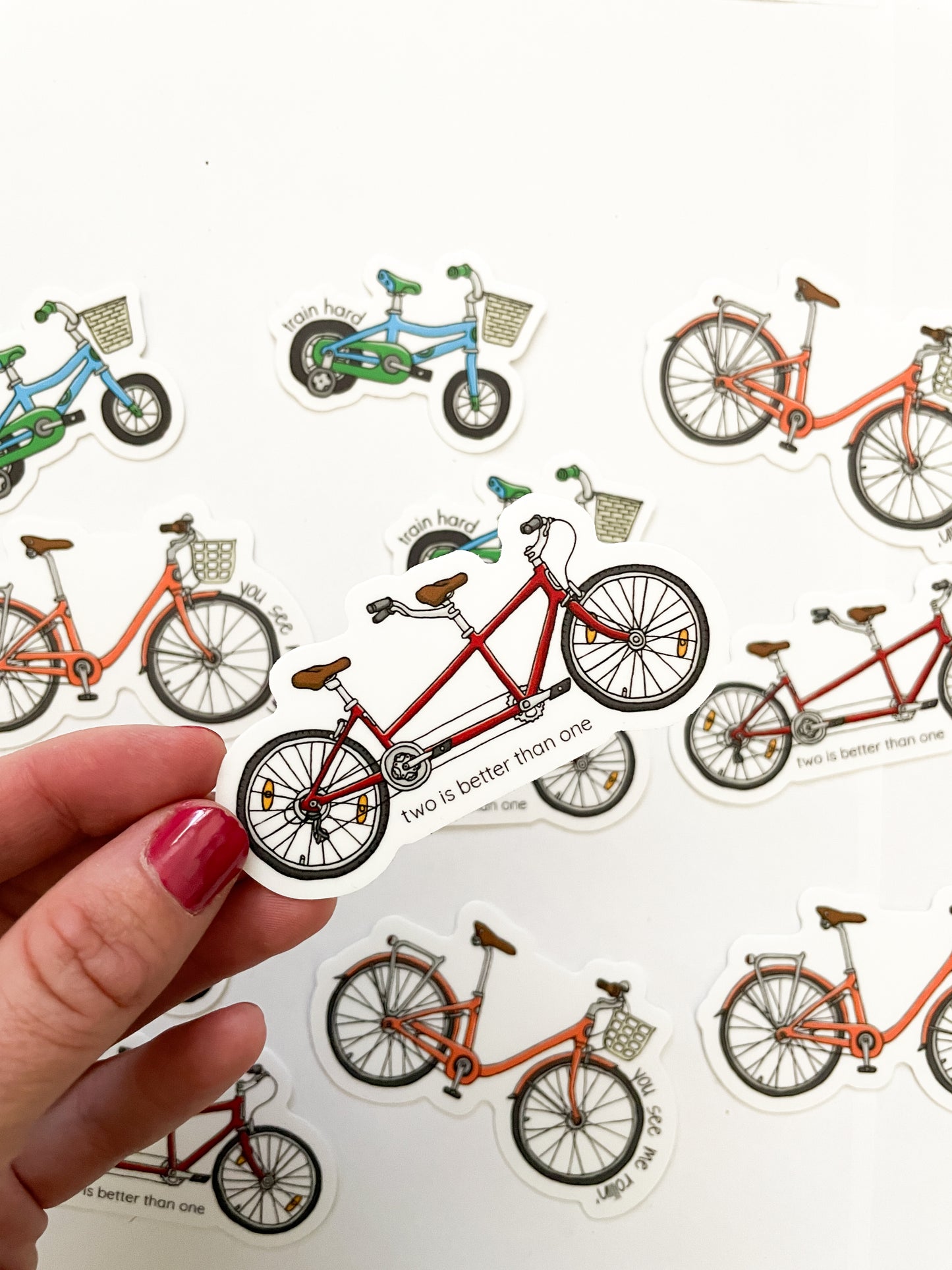 Red tandem bike sticker with punny saying, two is better than one on the front. Durable enough for cyclist, mountain biker, gravel bike, zwift, peleton. Vinyl sticker for hydroflask, nalgene, yeti, laptop, window