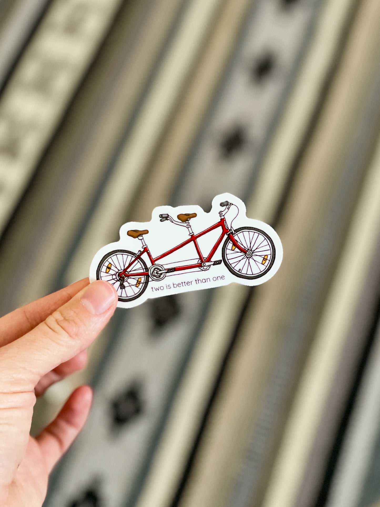 Red tandem bike sticker with punny saying, two is better than one on the front. Durable enough for cyclist, mountain biker, gravel bike, zwift, peleton. Vinyl sticker for hydroflask, nalgene, yeti, laptop, window